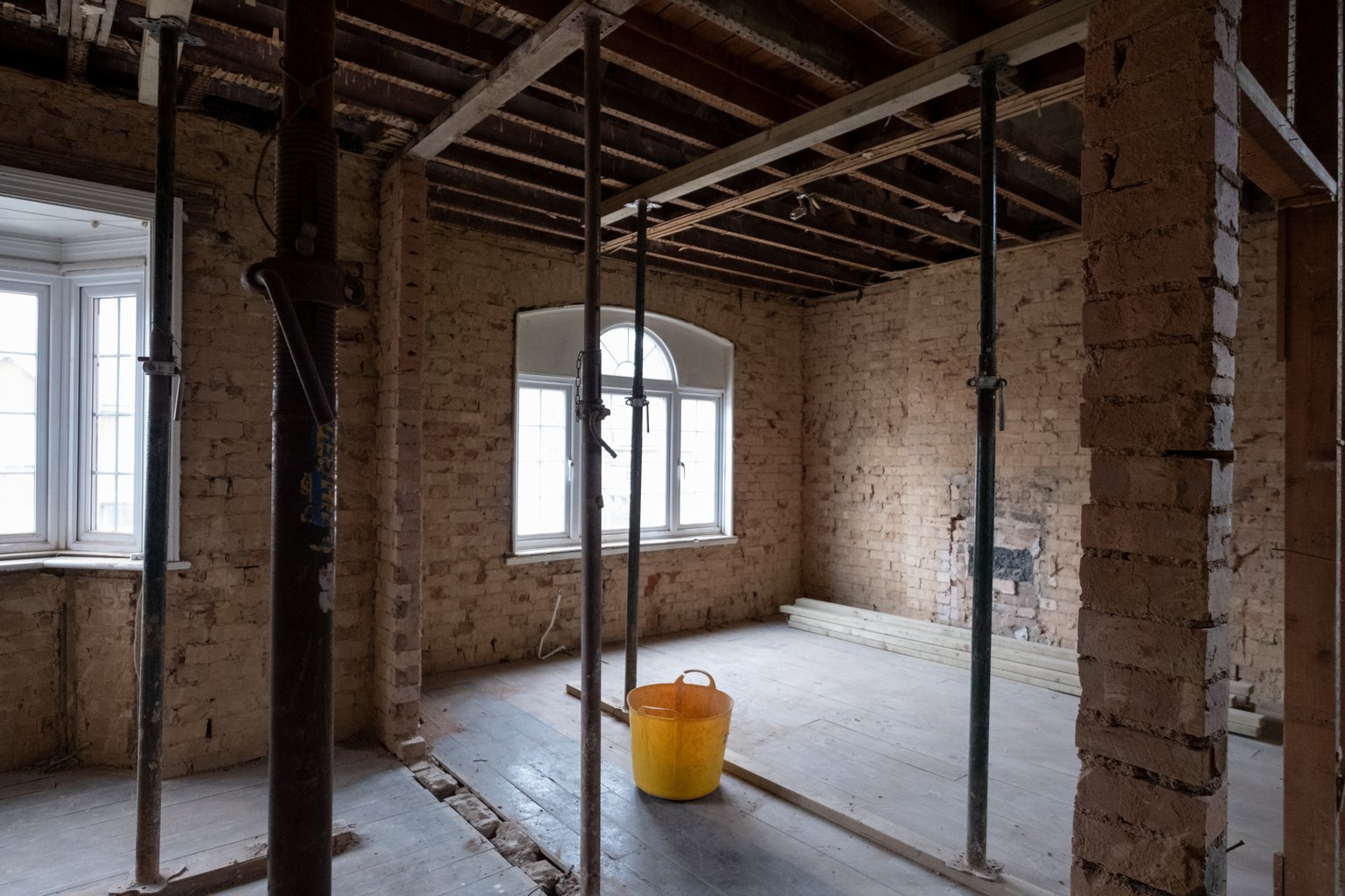 Interior renovation showing exposed brick walls in loft
