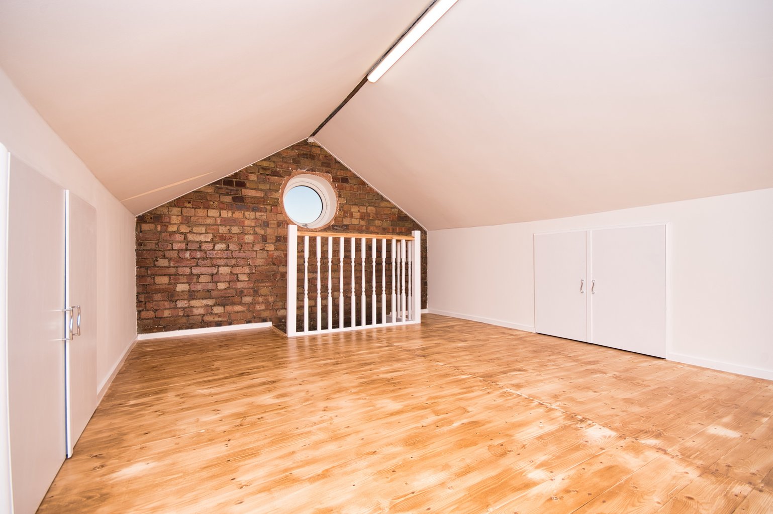 Professional loft conversion with exposed brick feature wall